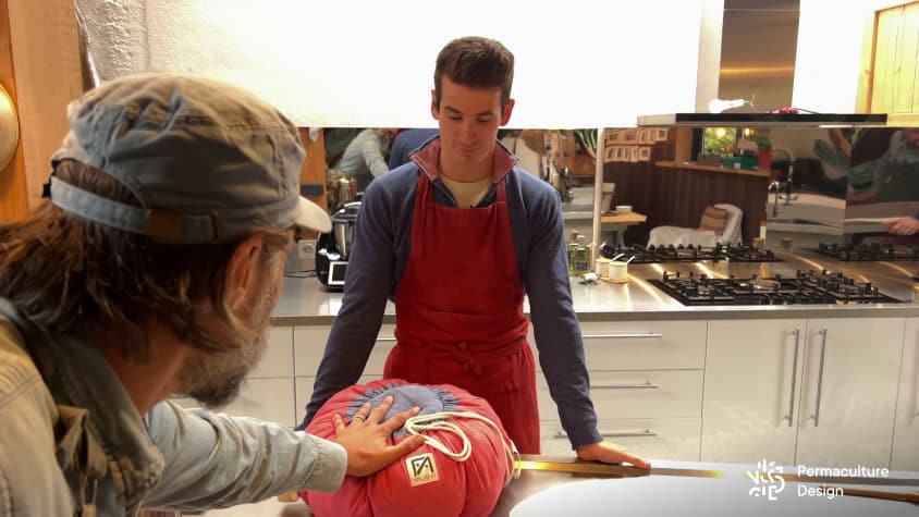 Christophe touche la marmite norvégienne fermée contenant un plat chauffé à 100 °C pour constater que ça ne brule pas du tout sur l’extérieur.